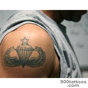 Artistic fine-line airborne tattoo design on the thigh