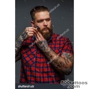 Huge Brutal Man With Tattoo Shawing His Beard With A Razor Stock _26